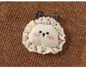 Gros plan sur une broche animale faite main avec dentelle et oreilles à carreaux