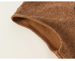 Gros plan sur la texture en tricot marron et la finition soignée de l'ourlet du gilet enfant