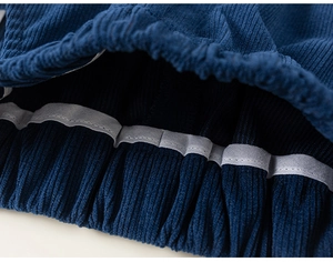 Détail de la texture en velours côtelé marine et poignet élastique sur vêtement enfant