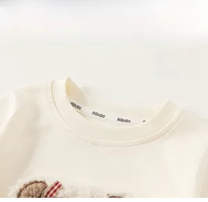 Detailed macro view of the classic round neckline on a creamy white cotton kids t-shirt