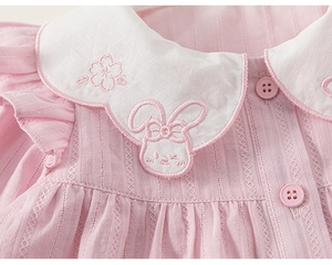 Detail of pink girls blouse featuring a scalloped Peter Pan collar with rabbit embroidery