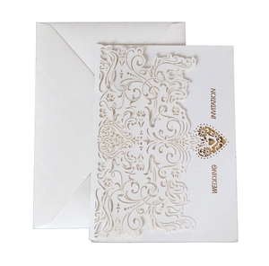 Elegant white laser-cut wedding invitation with golden heart and white envelope