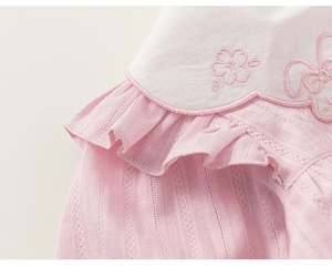 Close-up of pink cotton girl top with white scalloped collar and cute floral embroidery