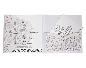 Detail showing laser-cut white wedding invitation set with RSVP card and lace pattern
