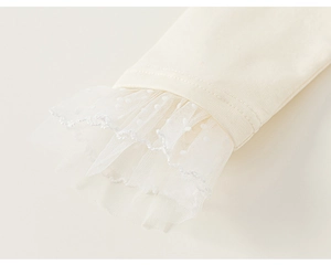 Close-up of girls long sleeve top featuring delicate dot mesh lace cuffs with scallop edges