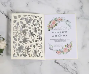 Laser cut snowflake wedding invitation set with floral inner card on marble background