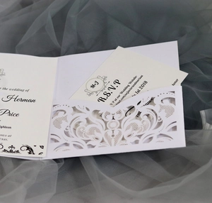 Elegant white laser-cut wedding invitation set with floral cover and RSVP card