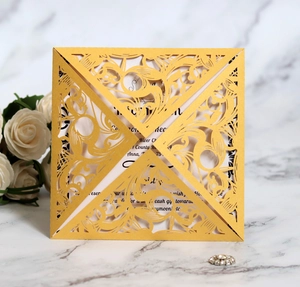 Macro shot of yellow laser-cut folding invitation card on elegant marble background