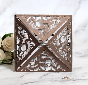 Detail of laser-cut floral wedding invitation in rose gold glitter paper with white card
