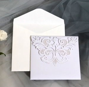 Detail of laser-cut wedding invitation with lavender floral pattern and white envelope