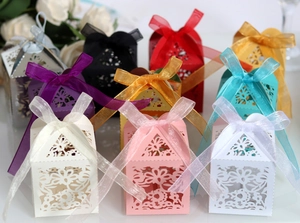 Laser cut hollow wedding favor boxes with elegant floral patterns and organza ribbons