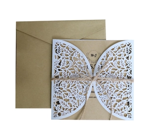 Macro detail of laser-cut floral wedding invitation with kraft envelope and twine tie