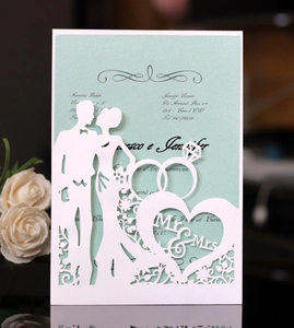 Detail of laser-cut wedding invitation showing bride groom silhouette and Mr & Mrs heart