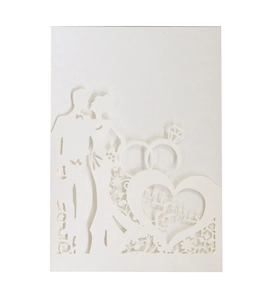 Macro shot of laser cut wedding invitation with Mr and Mrs heart design on white cardstock