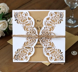 Macro shot of laser-cut wedding invitation with kraft paper and rustic twine detail