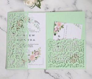 Macro view of mint green laser-cut wedding invitation set with floral lace detailing