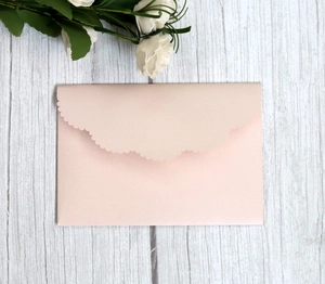 Elegant dusty pink laser cut wedding invitation envelope with scalloped edges and pearl finish