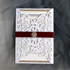 Kit d'invitation découpé au laser blanc avec carte pailletée dorée et ruban bordeaux