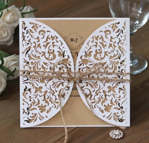 Detail of laser-cut floral wedding invitation with kraft paper and rustic hemp rope tie