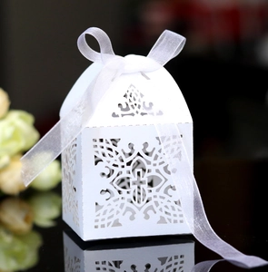 Detail of laser-cut cross and floral hollow design on white wedding favor box