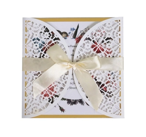 Elegant laser cut white lace invitation card with a cream ribbon and floral inner sheet