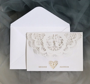 Elegant white laser-cut wedding invitation card with intricate lace and bird patterns
