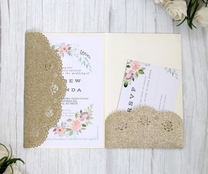 Close-up of glitter hollow-out laser cut invitation with elegant floral cards