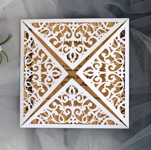 Detailed laser-cut heart pattern on white lace wedding invitation with kraft inner card