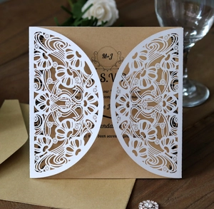 Macro view of laser-cut floral wedding invitation card with kraft paper insert