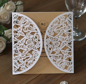 Close-up of laser-cut butterfly lace invitation with rustic kraft paper insert