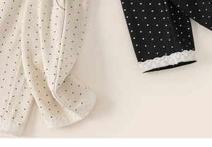Detail shot of toddler girl's polka dot wide-leg pants with elegant white lace cuffs