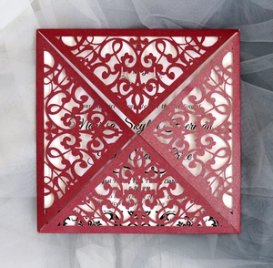 Intricate laser-cut floral pattern on a red pearlescent paper wedding invitation cover