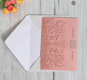 Pink laser-cut wedding invitation with double happiness symbol and white envelope