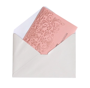 Elegant laser-cut wedding invitation with intricate floral patterns and matching envelope