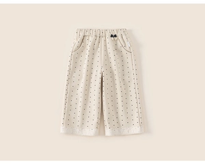 Detail view of cotton beige polka dot trousers for girls with delicate lace trim