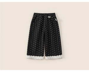 Detail of children's polka dot pants with white floral lace trim on the cuffs