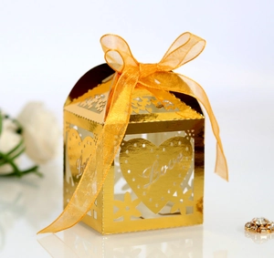 Close-up of golden hollow candy box with Love engraving and orange silk ribbon