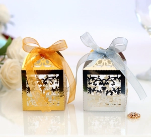 Laser cut vine pattern wedding favor boxes in gold and silver with ribbon bows