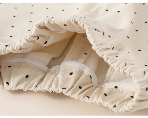 Macro detail of toddler polka dot trousers showing elastic waist and soft fleece lining