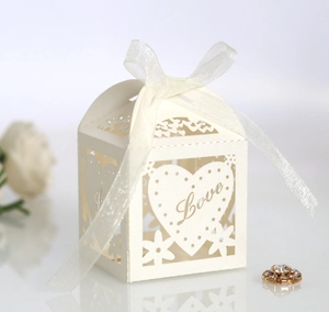 Detailed view of white laser-cut wedding candy box with Love text and ribbon bow