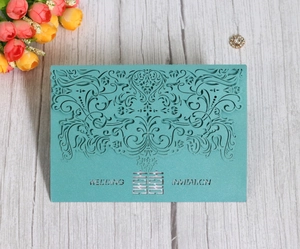 Detail of laser-cut floral pattern wedding invitation card with double happiness symbol