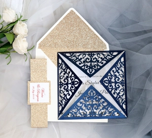 Detail of laser-cut navy invitation with gold glitter liner and elegant white rose decor