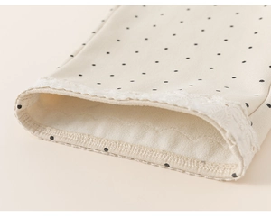 Close-up of cream polka dot pants featuring delicate lace trim and warm fleece lining