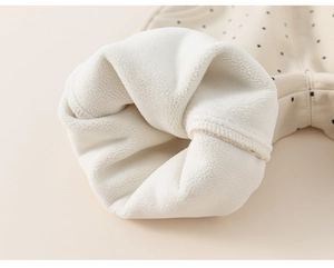 Detailed close-up of warm fleece lining and polka dot fabric on toddler girl trousers