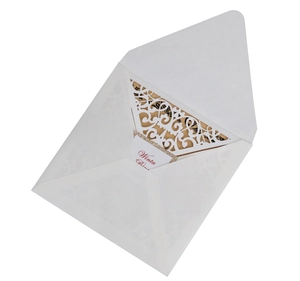 Detail of laser cut white wedding invitation set with elegant floral cutout and envelope