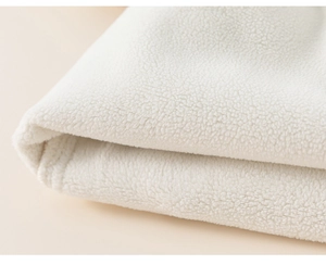 Close-up of soft white fleece fabric texture and neat stitching on children's pants