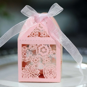 Laser-cut light pink wedding favor box with floral hollow patterns and white ribbon bow