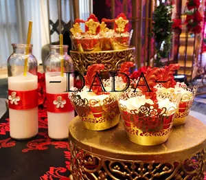 Nahaufnahme der goldenen lasergeschnittenen Cupcake-Hüllen und eleganter Partydekoration