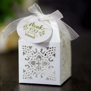 Geschenkschachtel aus weißem Papier mit Kreuz-Hohlmuster, Schleife und Anhänger