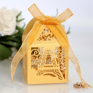 Golden laser-cut Eiffel Tower favor box with elegant organza ribbon and floral pattern